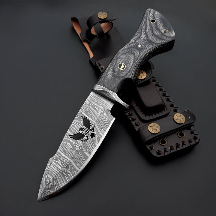 Forked blade knife with Damascus steel blade and wooden handle on a dark background
