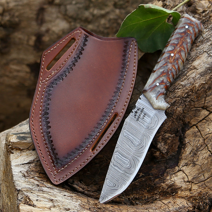 Knife with a leather sheath on a wooden surface