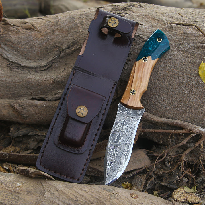 Knife with wooden handle and leather sheath on a natural background